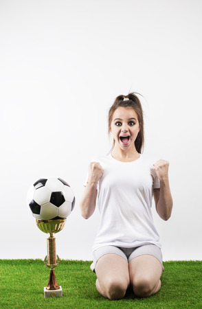 Happy soccer player celebrating victory on a soccer field. Gray backgroundの写真素材