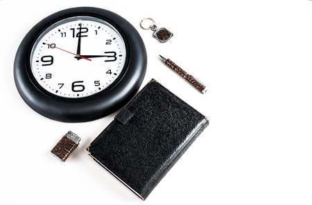 Collage. Notepad, pen, lighter and key chain are located next to the clock. White background.の写真素材