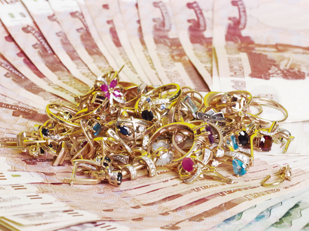Gold jewelry with sapphires, rubies, emeralds are on the banknotes.の写真素材