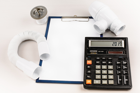 Plumbing supplies, calculator and a folder with a clip.の写真素材