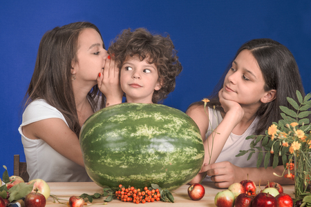 Happy kids with a whole watermelon on a blue backgroundの写真素材