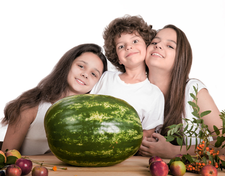 Happy smiling children with huge watermelon on white backgroundの写真素材