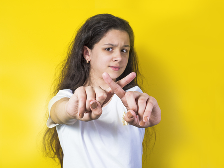 Young pretty brunette girl cross her arms to show gesture no isolated over yellowの写真素材