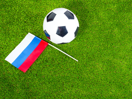 Football ball with the national flag of russia lies on the green fieldの写真素材
