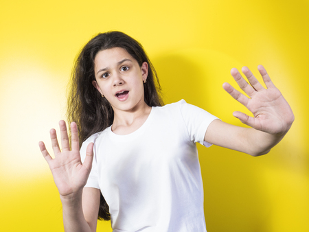 The young woman is afraid of fear. Yellow backgroundの写真素材