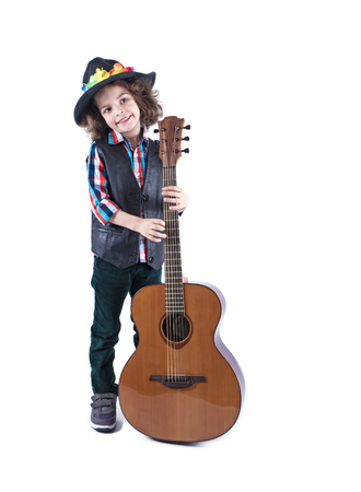 Funny little boy holds a guitar.Cute boy is standing with a guitar. White background.の写真素材