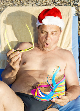 Santa Claus is resting on the Sunset on the beachの写真素材