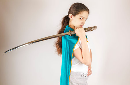 Young woman in a cape with a samurai sword