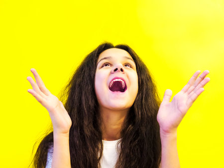 Beautiful girl. Joy emotions. Happiness. Yellow background.
