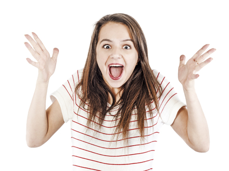 Happy young woman with opened mouth and wearing white shirt smiling and looking camera isolatedの写真素材
