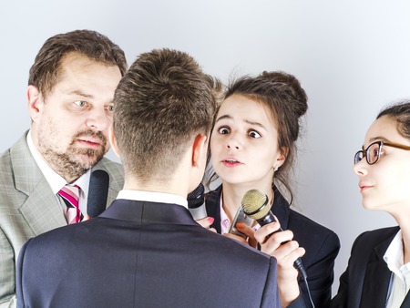 Young television reporters interviewed a man. Light background.の写真素材