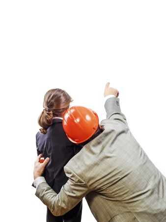 Adult architect in helmet with little boy pointing at copy space, isolated on white backgroundの写真素材