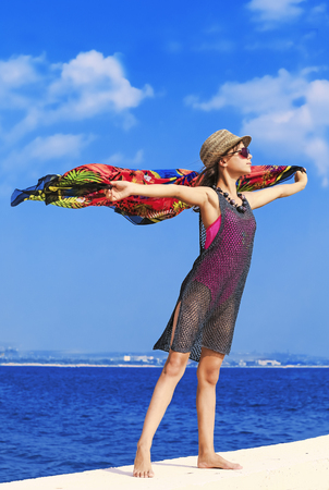 Beautiful young girl standing on a pierの写真素材