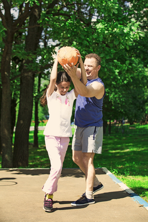 Father playing basketball with his child. A happy family.の写真素材