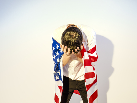 Depressive teenager with the flag of the United States, despair conceptの写真素材