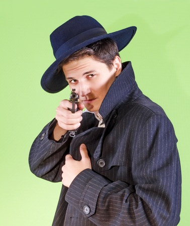 Handsome young man aiming the gun to an invisible target, with selective focusの写真素材