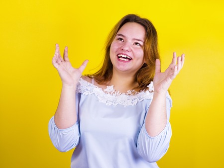 Portrait of a happy young woman isolated on a yellow backgroundの写真素材