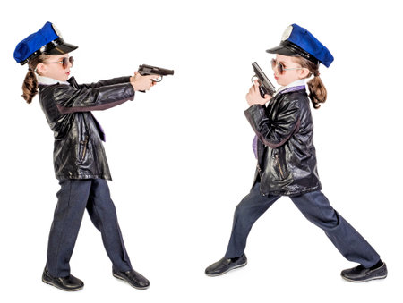 Boy in a tie and policeman's cap holding a gun in his hands, isolated on a white backgroundの写真素材