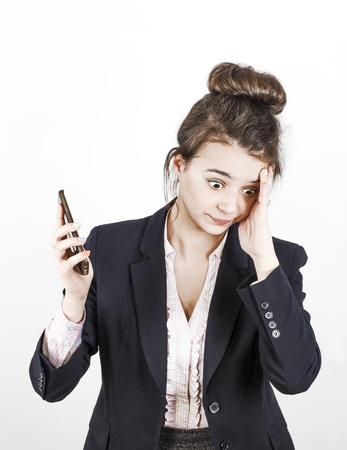 A business woman with a tired and irritated look takes the phone away from her ear trying to move away from the complaints of an obsessive and annoying customerの写真素材