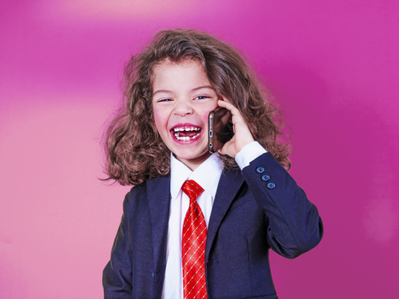 A small businessman holding a phone for a conversation with a smile and happy, isolated on a pink background. copy spaceの写真素材
