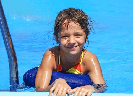 Pretty funny little girl in swimming poolの写真素材