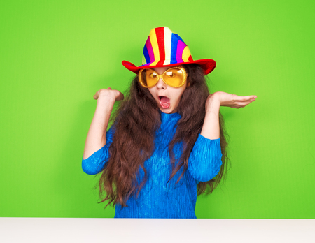 Funny beautiful surprised young votan on a green backgroundの写真素材
