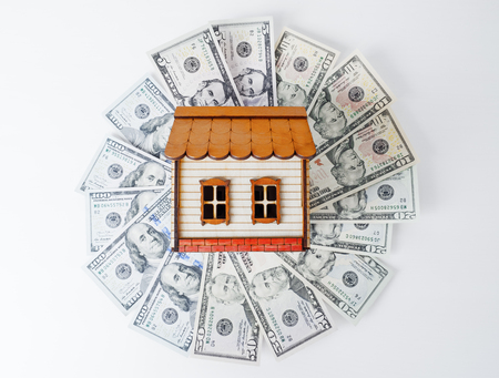Investment. Model house on top of money pile suggesting savings for a houseの写真素材