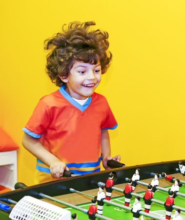 happy kid winning table football in a sports childrens clubの写真素材