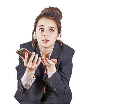 Shocking news Business and technology. Close up portrait of surprised young woman in formalwear using smart phone. Isolated on white. Copy spaceの写真素材