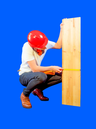 Young construction worker measuring wooden board. Blue background