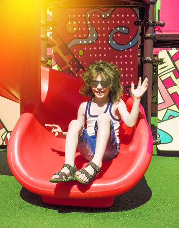 Cute little boy on a childrens playground on a sunny summer dayの写真素材