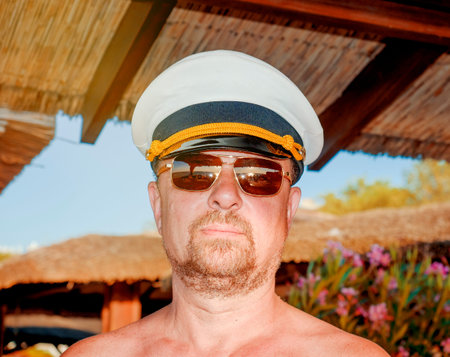 Funny bearded solid captain on the territory of a luxury resort. Travel adventure, seaman...