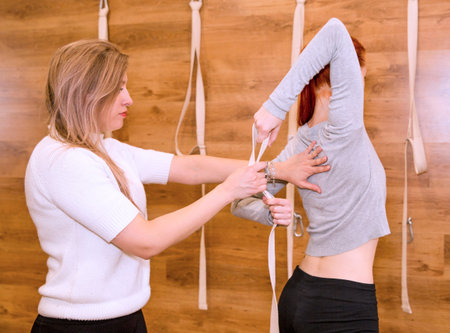A yoga guru teaches a student yoga exercises.