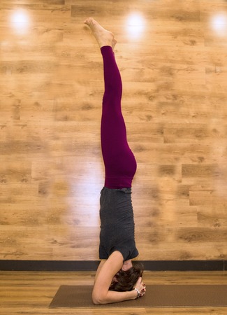 Young attractive woman practicing yoga, standing in Warrior one exercise. Working out, wearing sportswear, cool urban style, full length, studio background.の写真素材