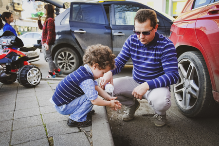 Washing Hand. Son and father on a walk, dad to pour water wash for you.の写真素材
