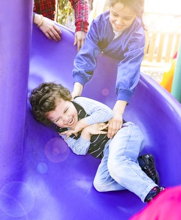 A little boy on a children's playground rides on a hill.の写真素材