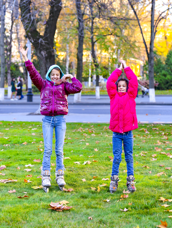 Happy children throw leaves in autumn parkの写真素材