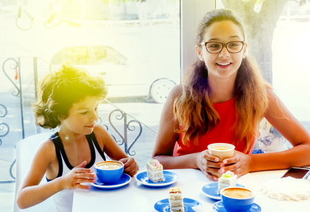 Two Children is Resting in Cafe. Children is Beautiful Young Brother and Sister. People is Drinking Tea From Cups.の写真素材