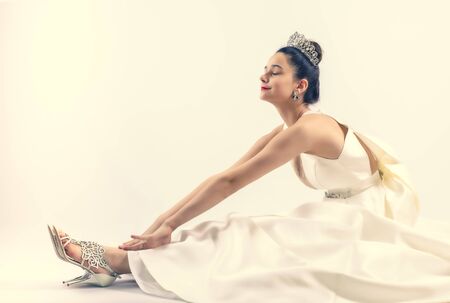The bride with closed eyes stroking her feet. sitting on the floor. Rest and relaxation concept. Copy spaceの写真素材