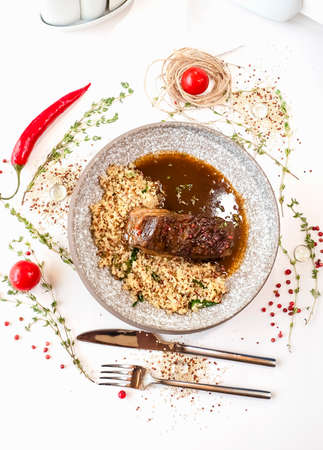 Stewed beef breast with quinoa in a gray marbled ceramic plate. Meat dish in the restaurant. Decor. Top view Selective focus. Super short focusの写真素材