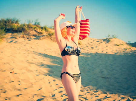 Pretty middle aged woman in black shiny swimsuit enjoying sand tropical beach. Travel and beach vacation conceptの写真素材