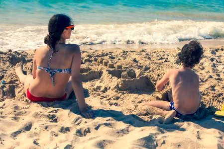 Bored kids on the sandy beach. Teens on the beachの写真素材