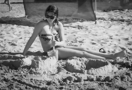 Bored kids on the sandy beach. Dramatic black and white photoの写真素材