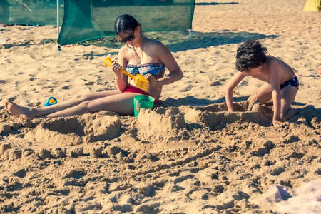 Bored kids on the sandy beach. Boredom and satiety conceptの写真素材