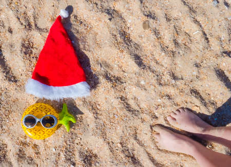 Santa Claus hat with masquerade goggles on sea coast. Christmas vacation On Sunny Dayの写真素材