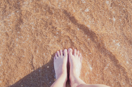 Relax on the ocean beach, female feet on the sea sand. Summer vacation conceptの写真素材