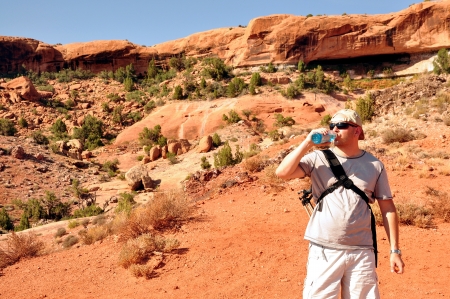 Photographer drinks water from a bottleの写真素材