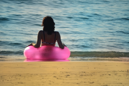 Women with pink ring at the oceanの写真素材