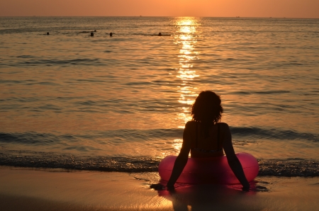 Women with pink ring at the oceanの写真素材