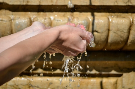Young woman washing hand under the stream of waterの写真素材
